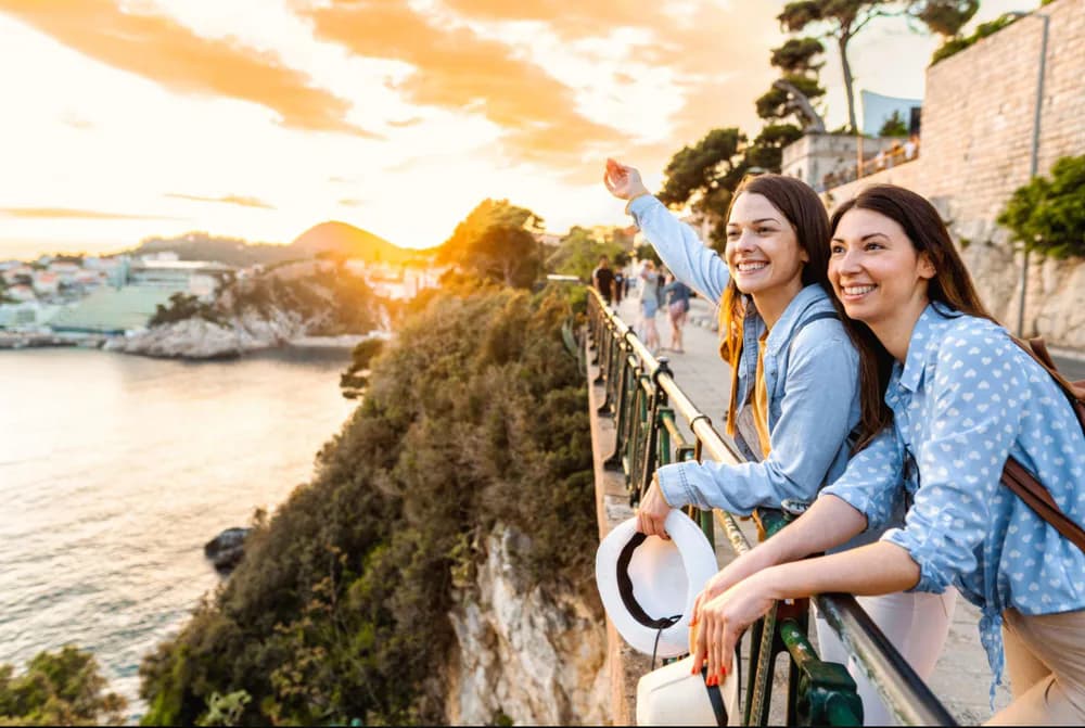 Travelers enjoying a coastal city view at sunset